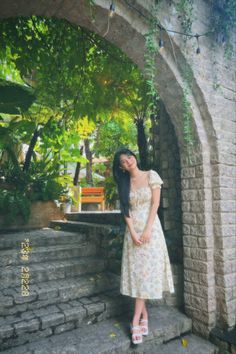 a woman in a dress standing on some steps