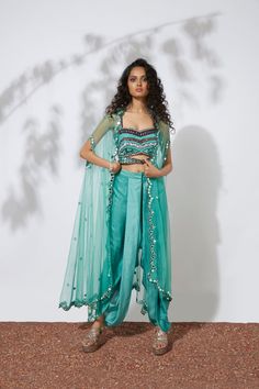 Aqua bustier embroidered with thread, tubes, pearls, beads & mirrors paired with pleated dhoti pants and mirror embellished net cape. This exquisite set is truly a work of art, with intricate embroidery and embellishments that sparkle and catch the eye. The bustier and dhoti pants are paired perfectly, while the net cape adds a touch of elegance and luxury. You'll feel like a true fashion icon in this stunning ensemble. Colour : AQUA Fabric : CREPE AND NET Embroidery details : HAND EMBROIDERY Co Turquoise Clothes, Cape Set, Fusion Wear, Beaded Mirror, Mehndi Ceremony, Aqua Fabric, Dhoti Pants, Embroidery Details, Wedding Wear