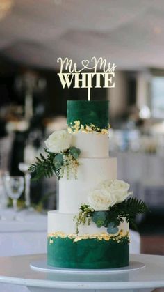 a white and green wedding cake sitting on top of a table