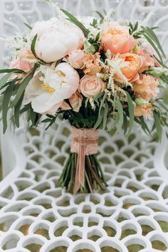 a bouquet of flowers sitting on top of a white chair