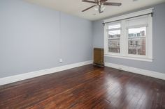 an empty room with hard wood floors and a ceiling fan