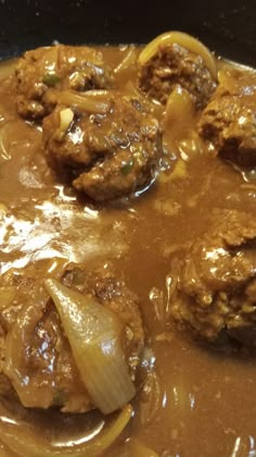 meatballs and onions are in a brown sauce