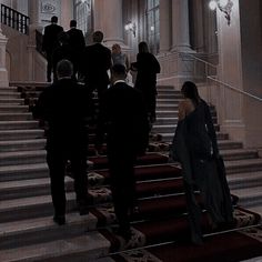 a group of people walking up and down the stairs in an old building at night