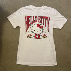 a hello kitty t - shirt is laying on the floor