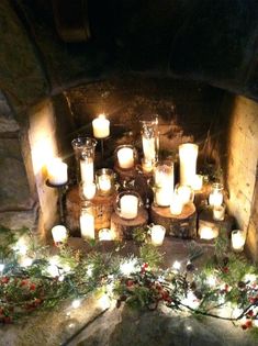 many candles are lit in front of a fireplace