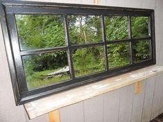 an old window reflecting the woods outside