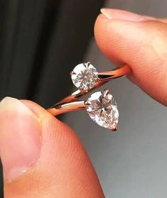 a person holding two diamond shaped rings in their hand, with one being held by the other