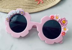 Brand new to MeaganElizabethCo, custom pastel flower sunnies! We are so excited to be adding other fashion accessories to our shop for your littles! And who could pass up these adorable pink flower sunnies?!? These sunnies are the perfect accessory for any vacation, photoshoot, birthday party or everyday where! These sunnies can be customized by YOU for your little fashionista! Step 1: Pick your sunnies and font color   Step 2: Use PERSONALIZE BOX at check out to note NAME, WORD(S) A STANDARD SUNNIES ORDER WILL COME WITH YOUR PERSONALIZED WORD/NAME/SAYING AND FLOWER EMBELLISHMENTS VARYING IN SIZE AND COLOR BASED ON FONT SELECTION AND LENGTH OF PERSONALIZATION  PRODUCT DETAILS:  SUNGLASSES ARE SIZED FOR TODDLERS/YOUNG KIDS UP TO AGE 10 *All letters are capitalized  Lightweight but sturdy. A Pink Personalized Adjustable Sunglasses, Spring Gift Sunglasses With Uv Protection, Customizable Pink Sunglasses For The Beach, Spring Gift Sunglasses With Gradient Lenses, Personalized Pink Sunglasses For Beach, Spring Gift Sunglasses With Tinted Lenses, Spring Gift Sunglasses With Adjustable Fit, Spring Gift Adjustable Sunglasses, Spring Tinted Sunglasses As Gift