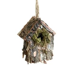 a birdhouse hanging from a rope with moss on it's roof and door