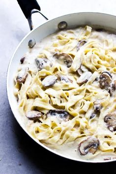 a skillet filled with pasta and mushrooms