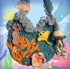 there is a crocheted fish and sea animals on the ocean floor