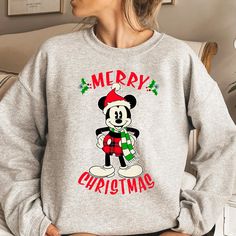 a woman wearing a mickey mouse christmas sweatshirt