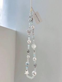 a close up of a necklace with beads and charms hanging from it's side