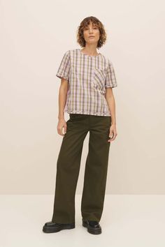 An elevated everyday top made from 100% certified fairtrade organic cotton poplin shirting in a joyful woven check. the adrian top has a standard fit with bust darts for gentle shaping and side splits for ease of wear. it features a binding detail at the cuffs and hem and fastens with a button and loop at the back.    this garment is completely plastic-free. Plaid Cotton Tops For Daywear, Plaid Short Sleeve Tops For Work, Relaxed Fit Cotton Tops For Workwear, Plaid Cotton Work Tops, Green Cotton Tops For Workwear, Green Cotton Workwear Tops, Green Cotton Tops For Casual Gatherings, Green Cotton Tops For Daywear, Pink Tartan