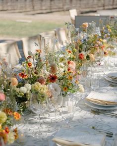 a long table is set with flowers and plates