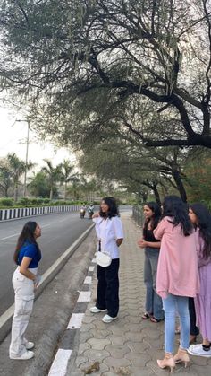 several people standing on the side of a road