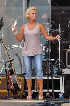 a woman standing on top of a stage holding a microphone