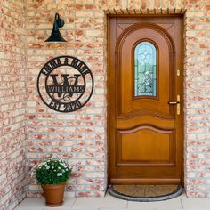 a wooden door sitting in front of a brick wall next to a potted plant