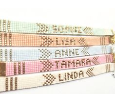 four cross stitch bracelets with words on them