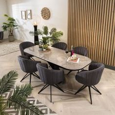 a dining room table surrounded by chairs and plants