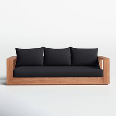 a wooden couch with black pillows on it