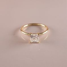 a gold ring with a princess cut diamond