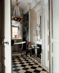 a room with a checkered floor and chandelier