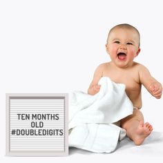 a baby sitting on the ground with a towel over it's head and text that reads ten months old double digits