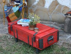 an old suitcase is turned into a coffee table with flowers on it and a potted plant