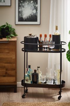 a bar cart filled with liquor bottles and glasses