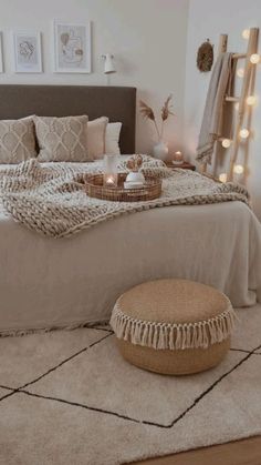 a bedroom with white walls and lights on the headboard, bed linens in neutral colors