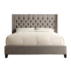 a bed with an upholstered headboard and buttons on the top of it