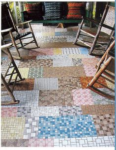 two rocking chairs sitting next to each other on top of a floor covered in multicolored tiles