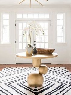 a living room with a table and vases on the rug in front of it