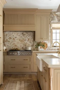 a kitchen with an oven, sink and counter tops in beige tones is pictured here