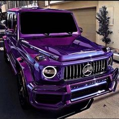 a purple mercedes g class parked in front of a building