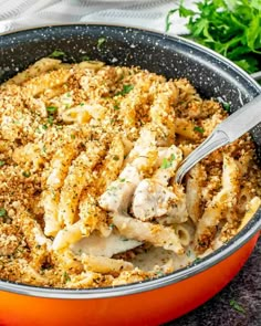 an orange casserole dish filled with chicken and parmesan bread crumbs