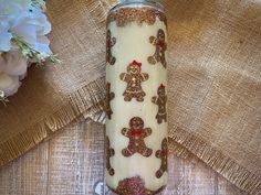 there is a candle that has been decorated with gingerbreads and other decorations on it