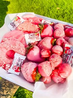 a box filled with lots of pink donuts covered in frosting and strawberries