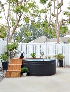 an outdoor hot tub surrounded by potted plants