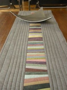 a table with a plate on top of it next to a rug and chair cushions