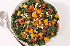 a white bowl filled with greens and sweet potato salad