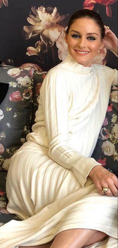 a woman sitting on top of a couch wearing a white dress