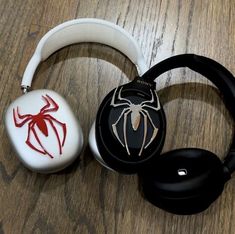 two headphones with spider - man designs on them sitting on a wooden table next to each other