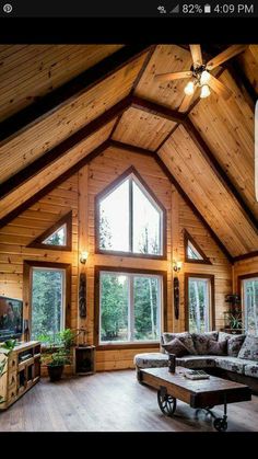 a living room with wood paneling and windows on the ceiling is shown in this image