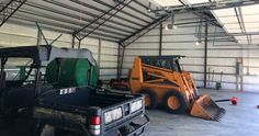 two vehicles parked in a garage next to each other with snow plow attachments on the back