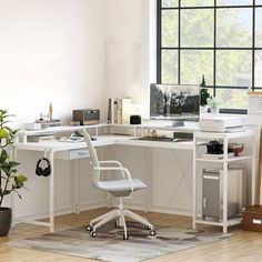 a white desk with a computer on top of it next to a plant and window