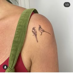 a woman's shoulder with two birds on it and one bird sitting on top of the other