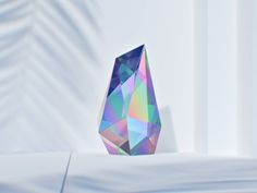 a multicolored diamond sitting on top of a white table next to a window