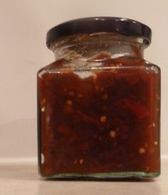 a jar filled with lots of food sitting on top of a table next to a wall